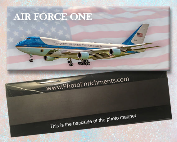 A fridge magnet with the United States Air Force One plane with a blue and white color scheme, accompanied by an American flag.